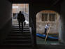 Man walking near gondola, classic Venician scene.