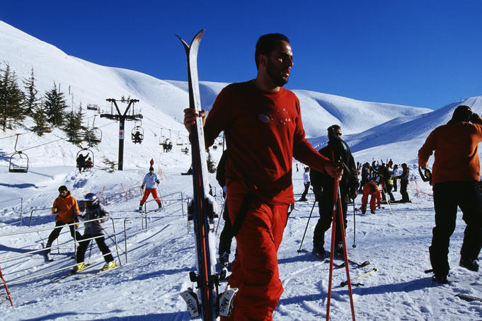 People at beginning of ski runs at resort.