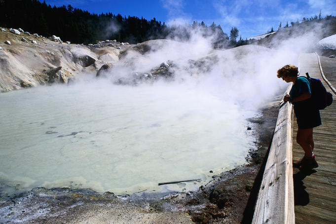 Visitor on boardwalk looking at fumaroles, Bumpass Hell.
