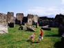 Boy and girl playing among Roman ruins.