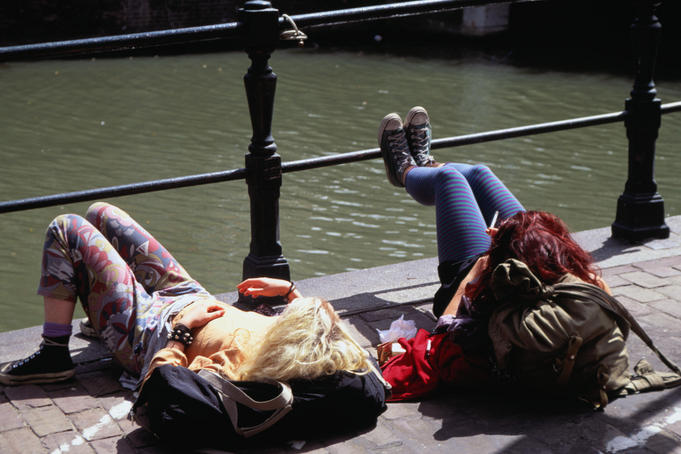 Dutch back-packers lounging by a canal - Amsterdam, North Holland