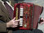 Street musician playing piano accordian.