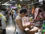 Butcher chops pork in Chinatown market.