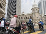 Motorcyclists at stop light in front of Sultan Abdul Samad Building, High Court building.