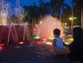 Mother with child watch spotlit waters of Malate Fountain.