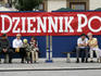 Locals and newspaper banner on Rynek Glowny.