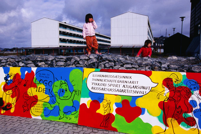 Inuit children playing in front of apartment buildings.
