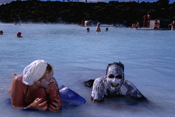 People enjoying silica mud treatment, Blue Lagoon geothermal complex.