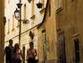 People walking down cobbled laneway in old town.