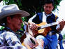 Men strumming guitars in Parque Libertad.