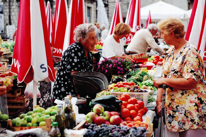 Trader and customer at morning market on Gunduliceva Poljana in old town.
