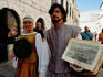 Street entertainers in traditional costume selling souvenirs on Placa in old town.