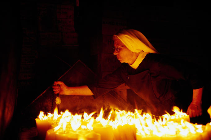 Nun attending candles at Stone Gate Shrine.