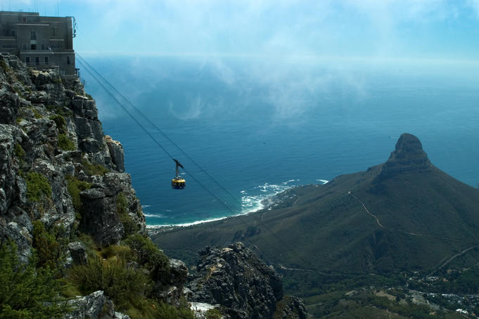 Cable car descending from Table Mountain, Lion's Head in background.