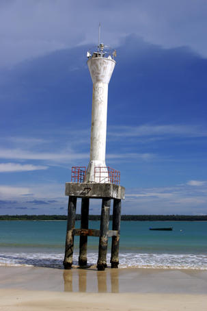 Lighthouse on platform at shoreline.