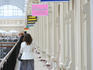 Signs and people inside GUM department store.