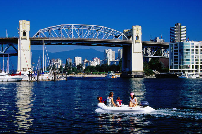 People on motorised dinghy in front of Burrard Street bridge.