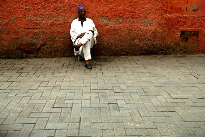Local man sitting near wall, Marrakesh