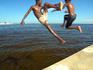 Kids leaping off marina into Haulover Creek, Belize Bay.