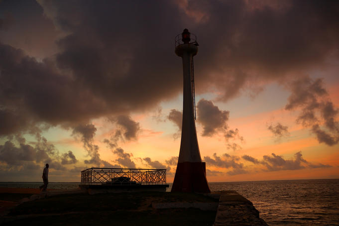Sunrise at Fort George Lighthouse with local man doing morning exercises.