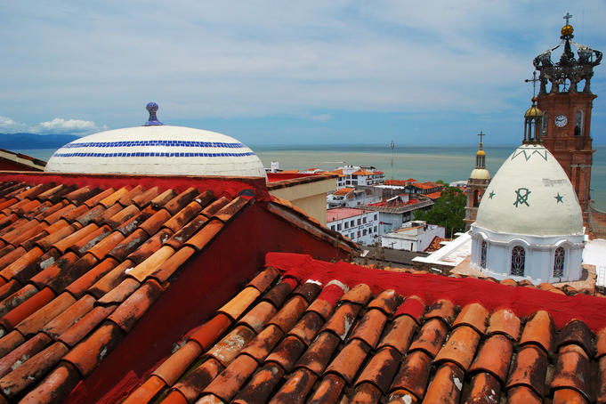 Terracotta rooftop in Zona Centro, Templo de Guadelupe , Bay of Banderas in background.