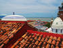 Terracotta rooftop in Zona Centro, Templo de Guadelupe , Bay of Banderas in background.