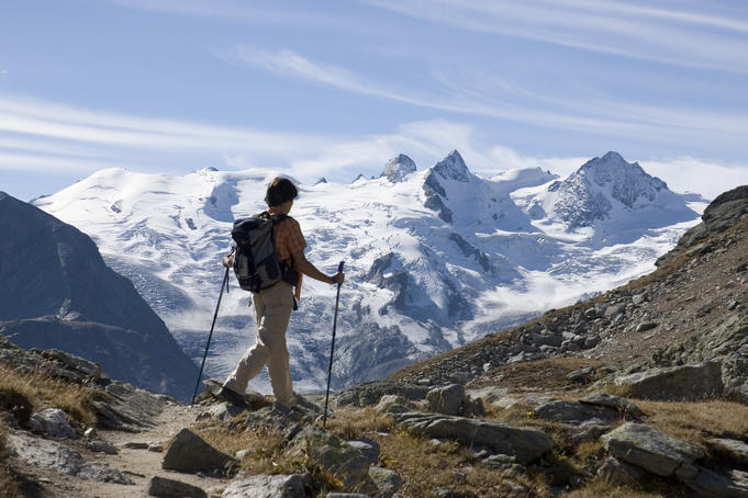 Hiker in Val Roseg with La Sella and Il Caputschin in background.