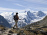 Hiker in Val Roseg with La Sella and Il Caputschin in background.