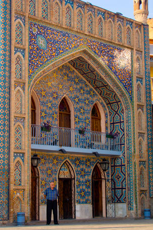 Man standing outside mosque-like Orbeliani Baths.