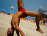 Young man doing Capoiera on beach.