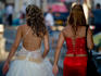 Bride with her bridesmaid walking down street.