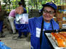 Woman with fantastic glasses selling sandwiches and pizza at Ladies Market.