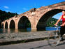 Woman cycling past Alte Brucke.