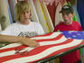 Young guys examining a surfboard in a beachfront shop.
