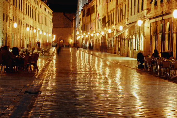People sitting at tables on Placa at night.