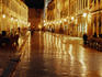 People sitting at tables on Placa at night.