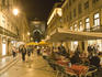 People sitting outside along Rua Augusta, Baixa.