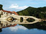 Four-arched bridge of Rijeka Crnojevica reflected in Lake Skadar.