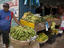 Man selling bananas at produce stall next to harbour.