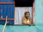 Woman at window of colourful house, Little Corn Island.