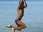 Boy swinging from rope over sea, Little Corn Island.