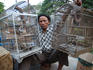 Vendor holding up his birds at Pasar Senggol bird market.