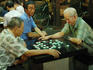 Elderly men playing checkers in Chinatown.