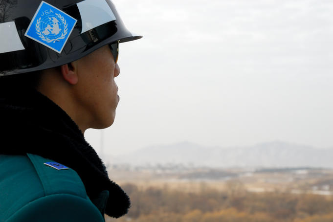 South Korean ROK soldier in Joint Security Area looking to the North across DMZ.