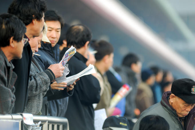 People studying form guide at Seoul Racecourse.