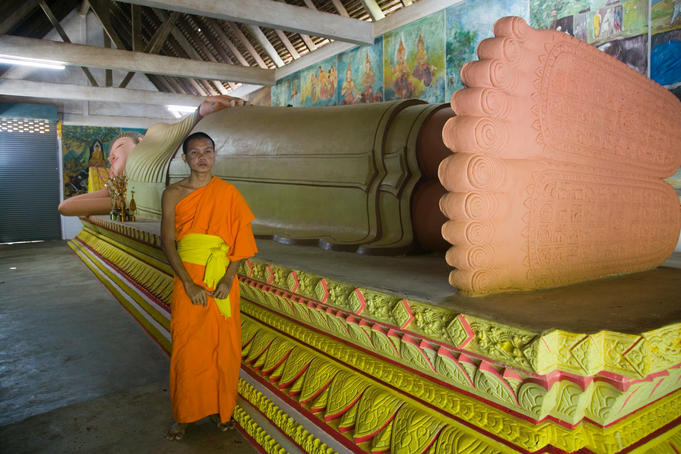 Yyoung monk in front of reclining Buddha, Wat Rathana Ransi.