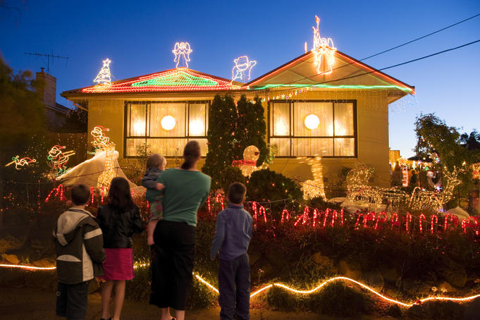 Family enjoy Christmas Light of suburban house.