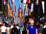 Drottninggatan, shoppers below flags.