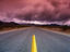 Desert Road with clouds in distance.