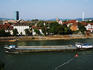 Long freight ship on Rhine River in front of houses at Kleinbasel.